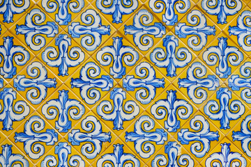 Marble-stone mosaic texture. Ornamented tiles texture background. ancient Spanish, european yellow and blue mosaic, Picturesque Europe city wall.