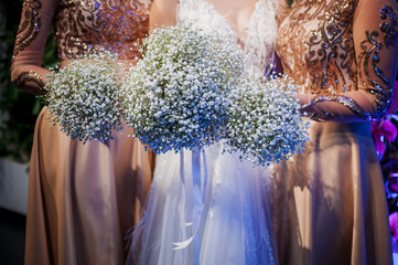 Girls holding white bouquets of flowers in the hands
