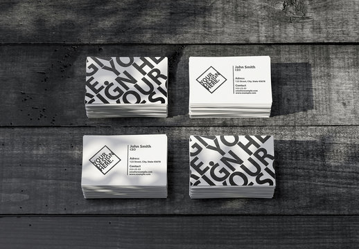 Four Stacks of White Business Cards Mockup on Black Wooden Table