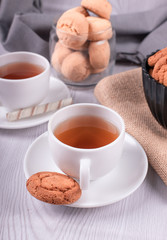 Two cups of tea with biscuit and chocolate
