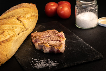 piece of steak on slate, with black background