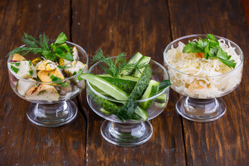 Pickles of cabbage, mushrooms and cucumbers with greens and seasonings