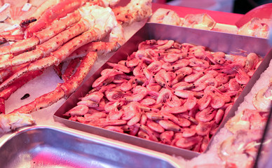 Pink frozen shrimps at the streetmarket. Frozen shrimps in ice. A lot of royal shrimp close-up.