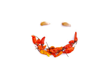 red chili and garlic to form a smiling face isolated from a white background and copy space