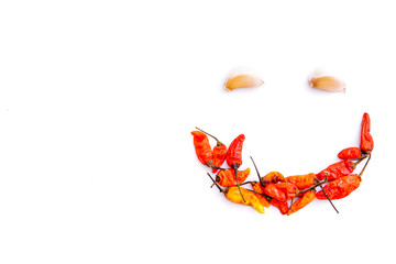red chili and garlic to form a smiling face isolated from a white background and copy space