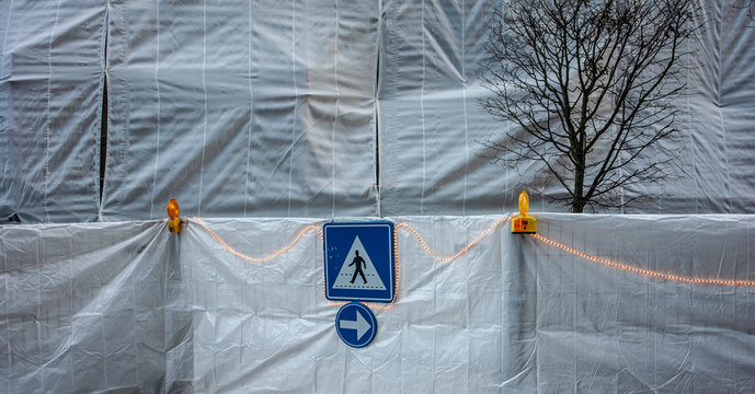 Dos se&ntilde;ales de trafico en una obra tapada con lonas en Bruselas