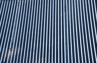 Vertical lines of silver color metallic form an unusual background.