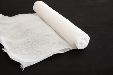 rolled up bandage on a black background. Material for the manufacture of masks for protection against the virus.