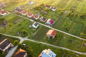 Aerial landscape of small town or village with rows of residential homes and green trees.