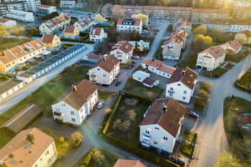 Aerial view of residential houses with red roofs and streets with parked cars in rural town area. Quiet suburbs of a modern european city.