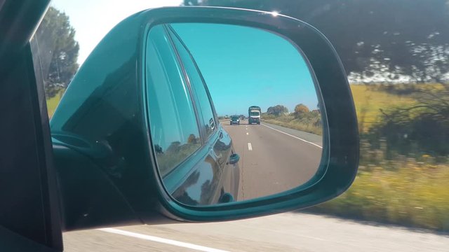 Footage from inside of a car towards a car side mirror on a highway between Casablanca and Rabat, Morocco