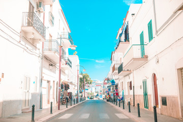 Obraz premium The narrow streets of the island with blue balconies, stairs and flowers.