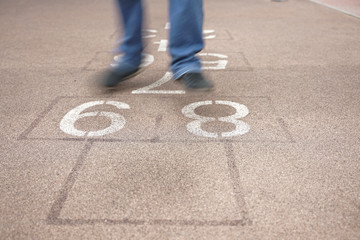 teenager playing hopscotch on playground outdoors, children outdoor activities