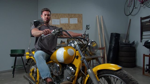 Men sits on motorcycle and starts the engine 