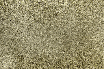 Golden black glitter twinkle abstract winter or Christmas holiday background with sparkles. Modern luxury mock up with sequins. Texture of colored porous rubber with spangles