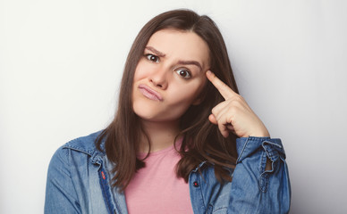 Photo of attractive pupil tries to memorize something, keeps fore finger on temple, reminds...