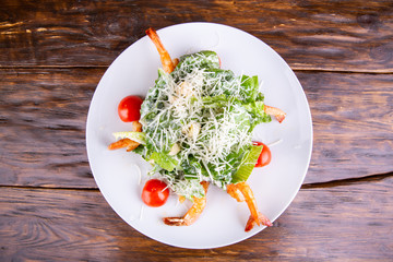 Seafood salad sprinkled with grated cheese, tomatoes and lettuce leaves