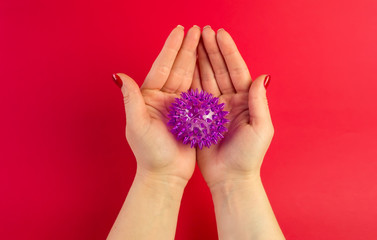 Doctor's hand holding virus of COVID-19 novel coronavirus as dangerous flu strain cases as a pandemic on red background. World epidemia concept