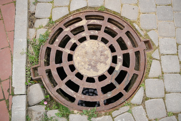 Manhole cover. old brown rusty sewer cover with nobody. top view.