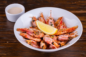 Shrimp boiled, served with a slice of lemon and finely chopped greens