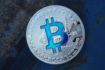Macro shot of Bitcoin. Blockchain technology,BTC. Blue metal background,Silver Coin with a blue letter B