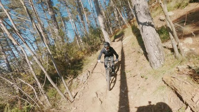 Speed riding downhill MTB bike down a rocky mountain on a sunny day. View from first person perspective POV.