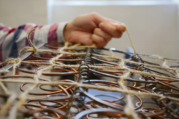 Upholstery springs. Upholstery worker tying old srpings. Upholstery workshop. Old chair springs...