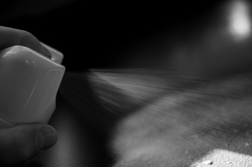 disinfectant being spayed from an aerosol can onto a metal black desk