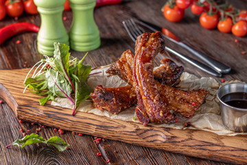 Baked pork ribs marinated in soy sauce served on a wooden board, restaurant dish, Horizontal orientation