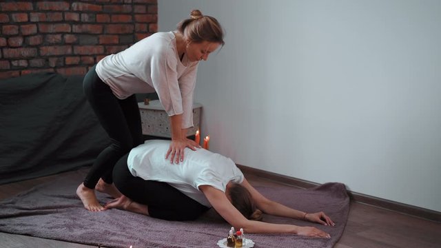 Relax and enjoy in spa salon getting thai massage by professional masseur Woman lying floor blanket Body care Hands treatment Acupressure trigger points Prevention muscles pain stretching flexibility