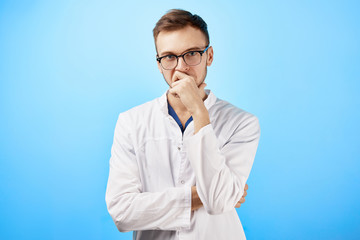 Portrait of intern doctor in white medical coat and glasses with a serious face expression isolated...