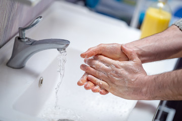 man washes his hands with soap at home. concept virus protection. hand hygiene.