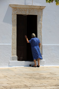 Naxos / Greece - August 25, 2014: A woman near a door, Naxos, Cyclades Islands, Greece