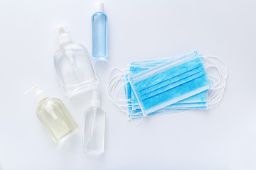 Coronavirus protection. Medical protective surgical masks, hand sanitizer bottles on white table. Alcohol gel antibacterial soap sanitizer, hands disinfection. Hygiene protection Coronavirus Covid 19