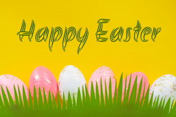 Concept of spring and Happy Easter pink and white with gold eggs on a colorful yellow bright background, grass cut out of paper