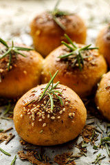 Baked rosemary rolls on baking parchment close up