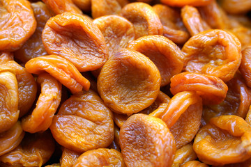 Orange and yellow dried apricot fruits, textured food background.