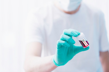 Obraz premium Doctor holds the blood test tube with positive test on coronavirus.
