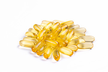 Bunch of omega 3 fish liver oil capsules in pile forming pattern background. Close up of big golden...
