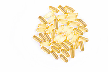 Bunch of omega 3 fish liver oil capsules in pile forming pattern background. Close up of big golden...