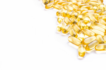 Bunch of omega 3 fish liver oil capsules in pile forming pattern background. Close up of big golden...