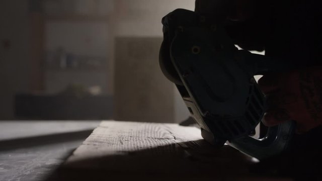 Mann schleift ein Holzbrett mit einer Maschine