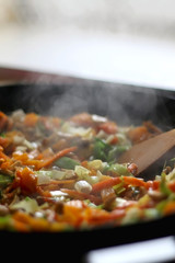 Stir- fry vegetables and portobello mushrooms in a wok. Selective focus.