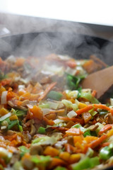 Stir- fry vegetables and portobello mushrooms in a wok. Selective focus.