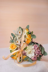 Stylish flowers arrangement in a pink hatbox. White orchid, purple and yellow roses with bunch. Birthday present. Flowers bouquet on background whith copy spase. Romantic concept