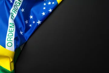 Wall murals Brasil Brazilian flag lying on black grainy background