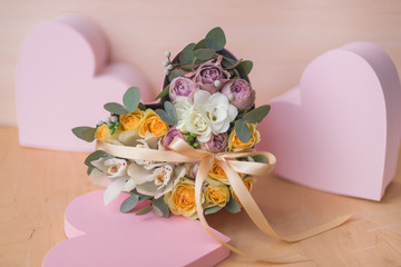 Stylish flowers arrangement in a pink hatbox. White orchid, purple and yellow roses with bunch. Birthday present. Flowers bouquet on background whith copy spase. Romantic concept