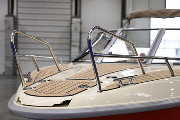 Powerboat bow deck close up with railing and brown marine teak covered floor