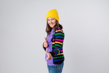 Happy schoolgirl in purple T-shirt and yellow hat on white background