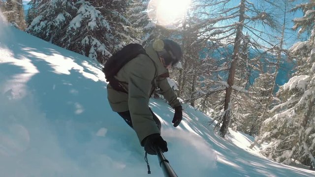 Happy snowboarder snowboarding down the slope on an epic powder snow day. A sunny winter day with blue sky.  Perfect travel destination, extreme sports, beautiful landscape and nature.